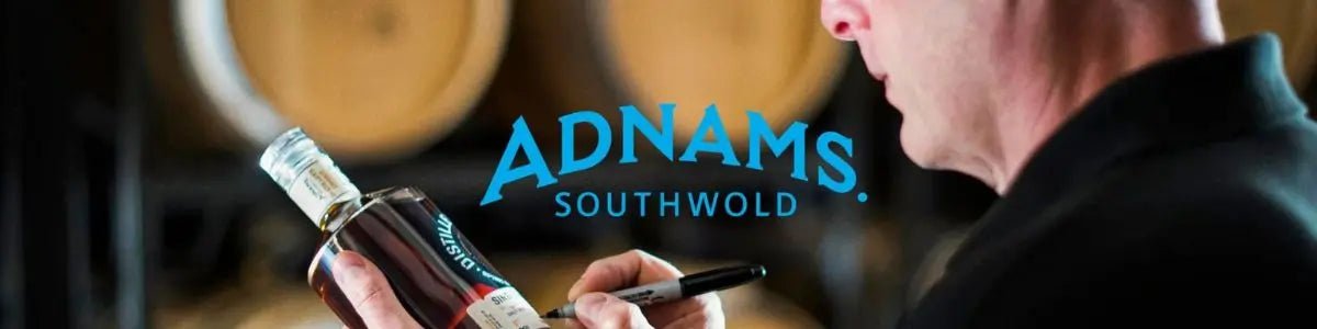 Man holding a bottle and writing on it with a pen with an Adnams logo overlay