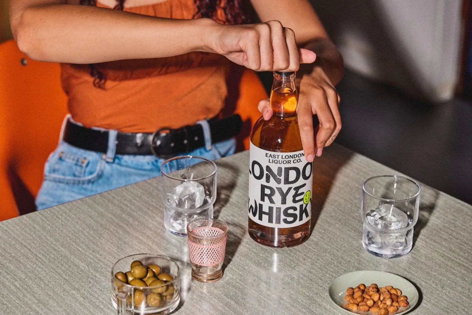 Person opening a bottle of East London Liquor Company London Rye Whisky