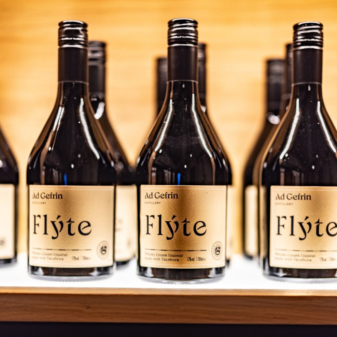 Bottles of Ad Gefrin Flyte Cream liqueur on a wooden shelf
