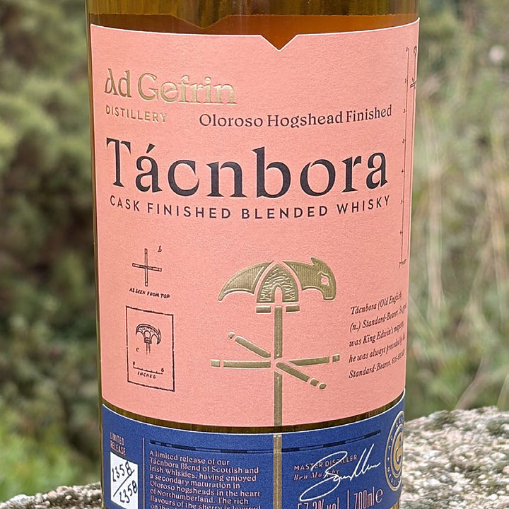 Tácnbora Oloroso Cask Finish bottle on a stone wall in the Northumberland hills