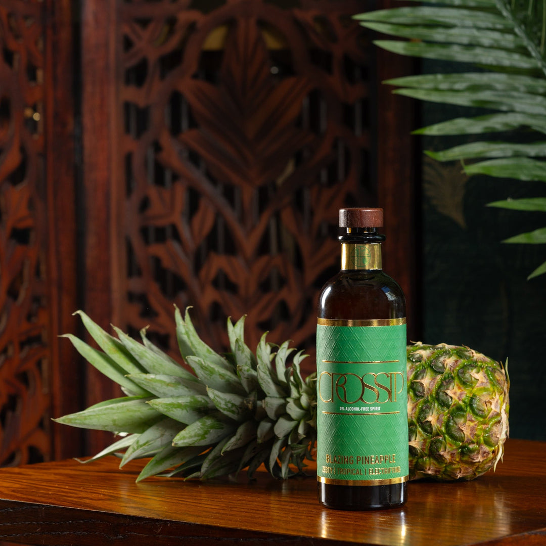 Bottle of Crossip Blazing Pineapple with a pineapple on a wooden surface with a decorative background