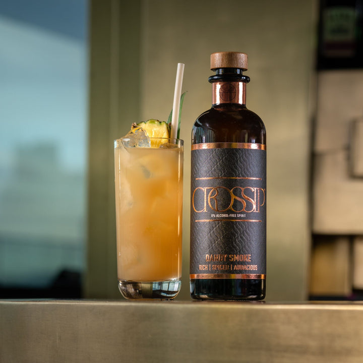 Bottle of Crossip Dandy Smoke with a cocktail on a bar counter