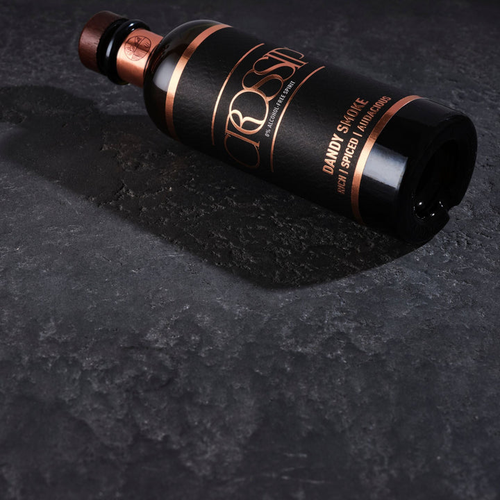 Crossip Dandy Smoke Black bottle with bronze accents on a dark textured surface