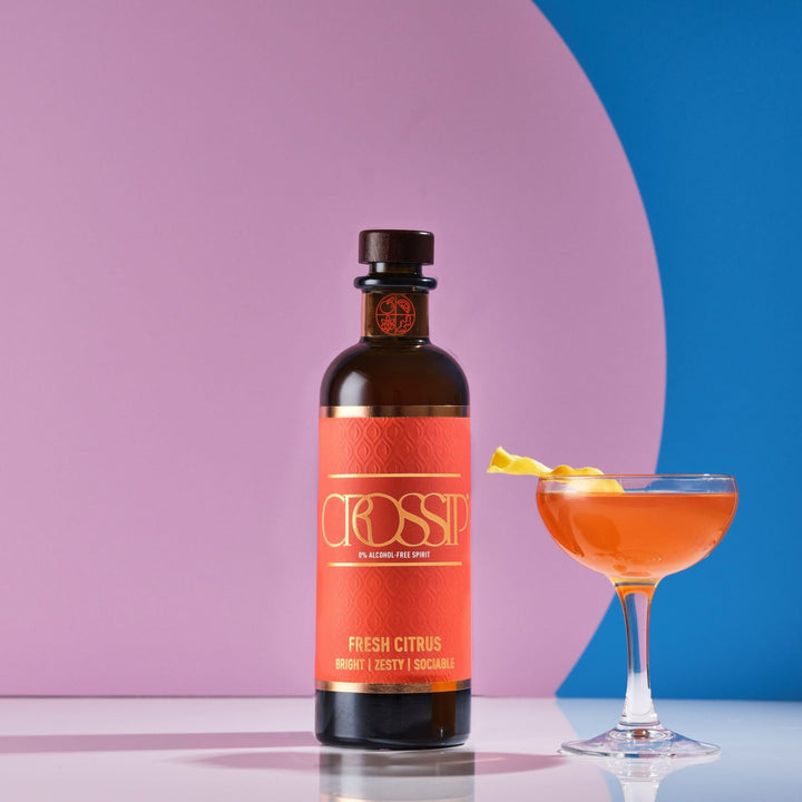 Bottle of Crossip Fresh Citrus with a cocktail on a pink and blue background