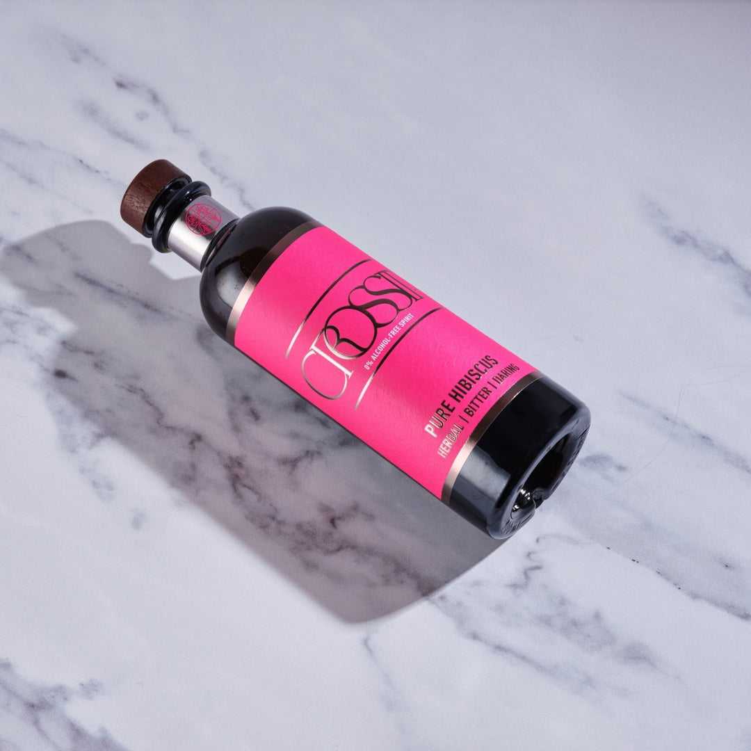 Crossip Pure Hibiscus Bottle with a pink label on a marble surface