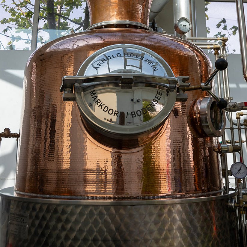 Copper still with a gauge in a distillery setting