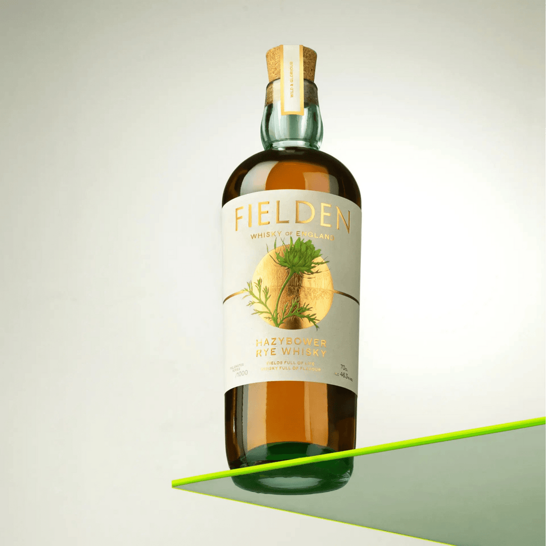 Bottle of Fielden whiskey on a reflective surface with a neutral background