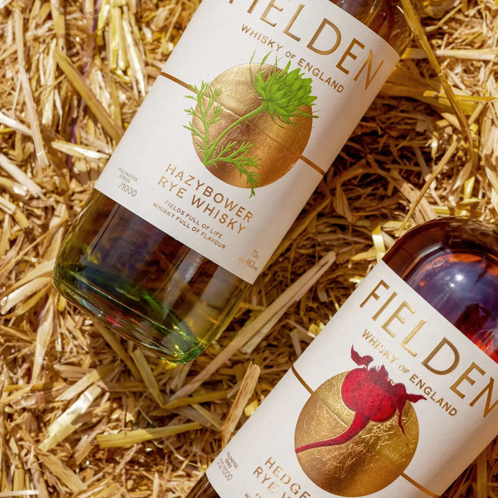 Two bottles of Fielden whisky on a bale of straw.