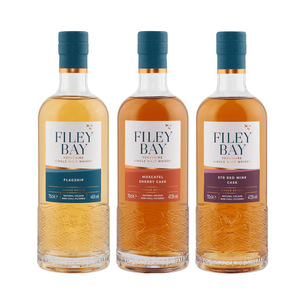 Three bottles of Filey Bay whisky on a white background