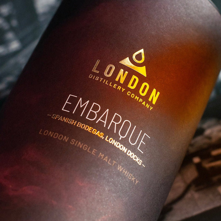 Whisky bottle with 'London Distillery Company' Embarque label on a dark background