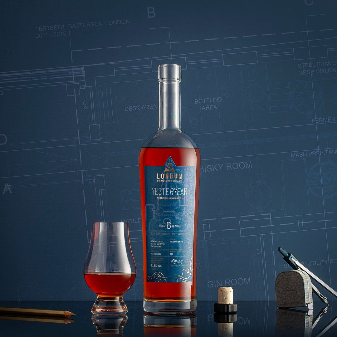 Bottle of London Distillery Company YESTERYEAR Whisky with a glass on a blue background
