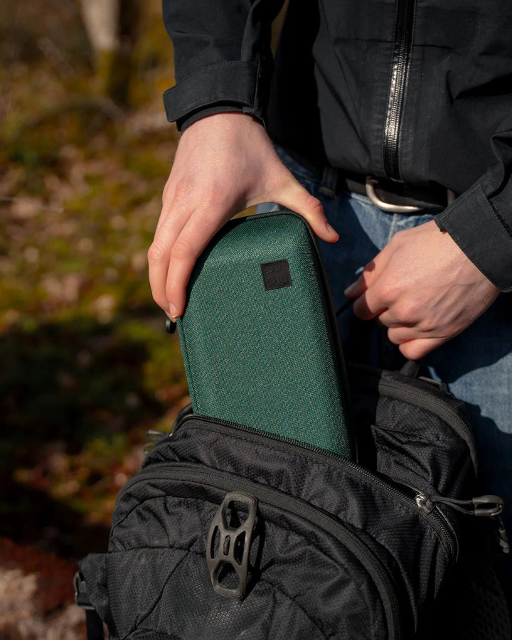 Oak and Ember Flight Flask Traveller Set in Forest Green being placed in a backpack