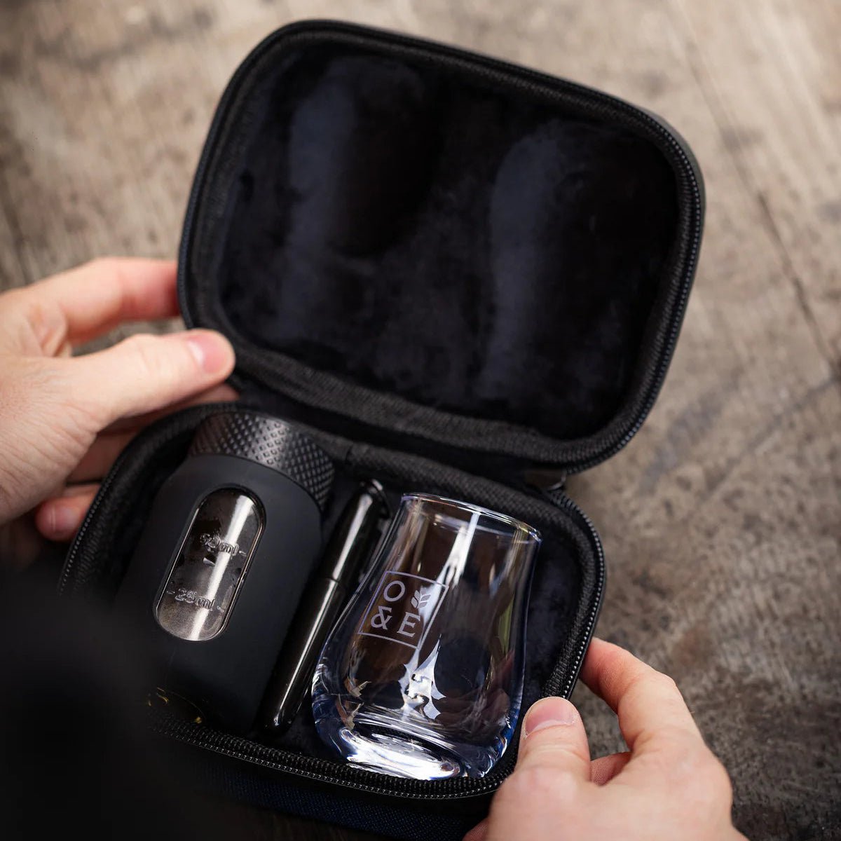 Oak & Ember carrying case flight flask and glass on a wooden surface