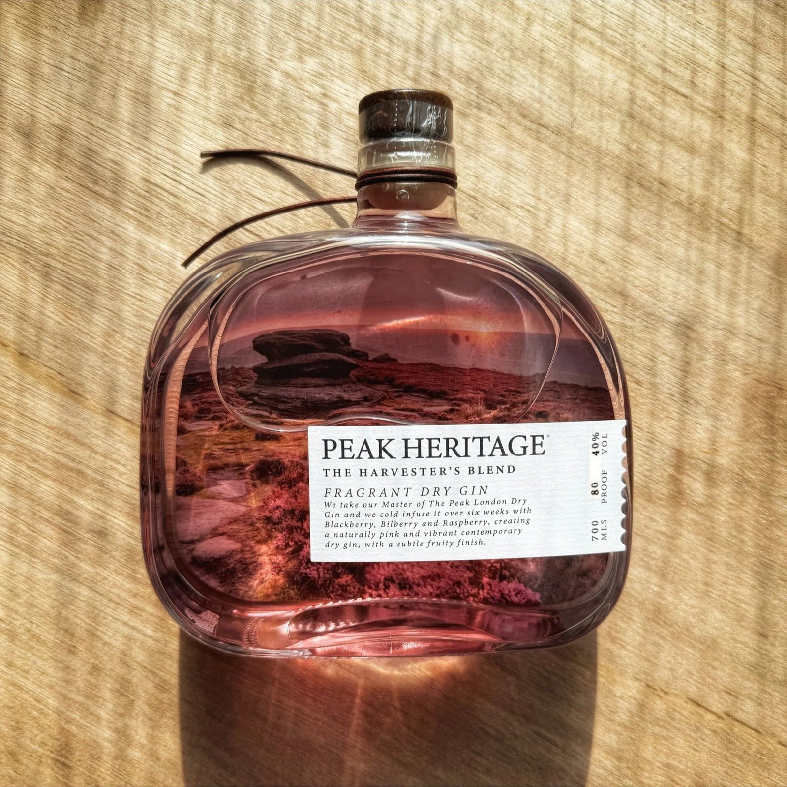 Bottle of Peak Heritage The Harvester's Blend Gin on a wooden surface
