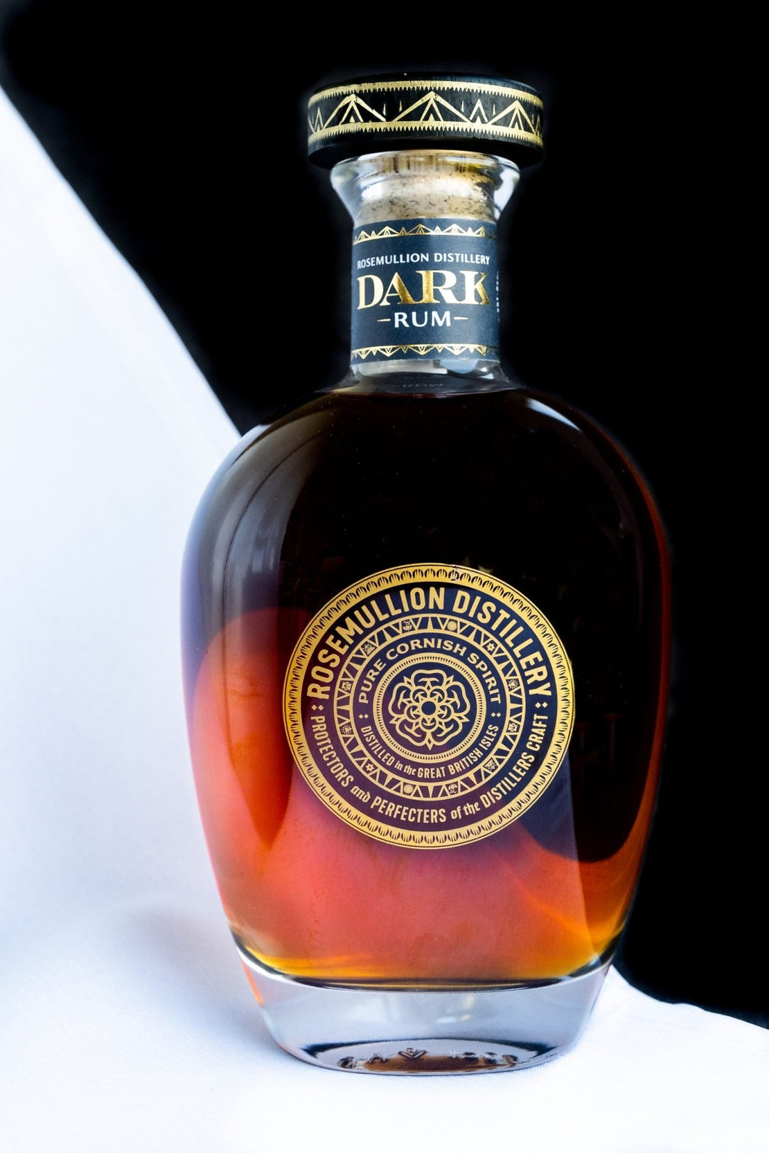 Bottle of Rosemullion dark rum with a gold label on a white background