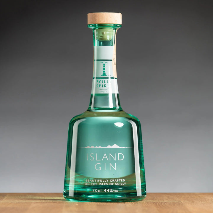 Green bottle of Island Gin on a wooden surface with a gray background