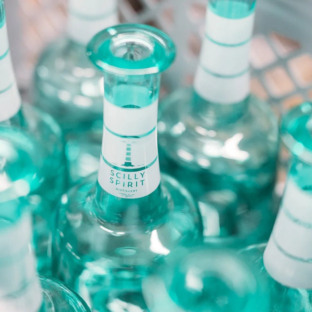 Teal glass bottles with white labels with Scilly Spirit on them