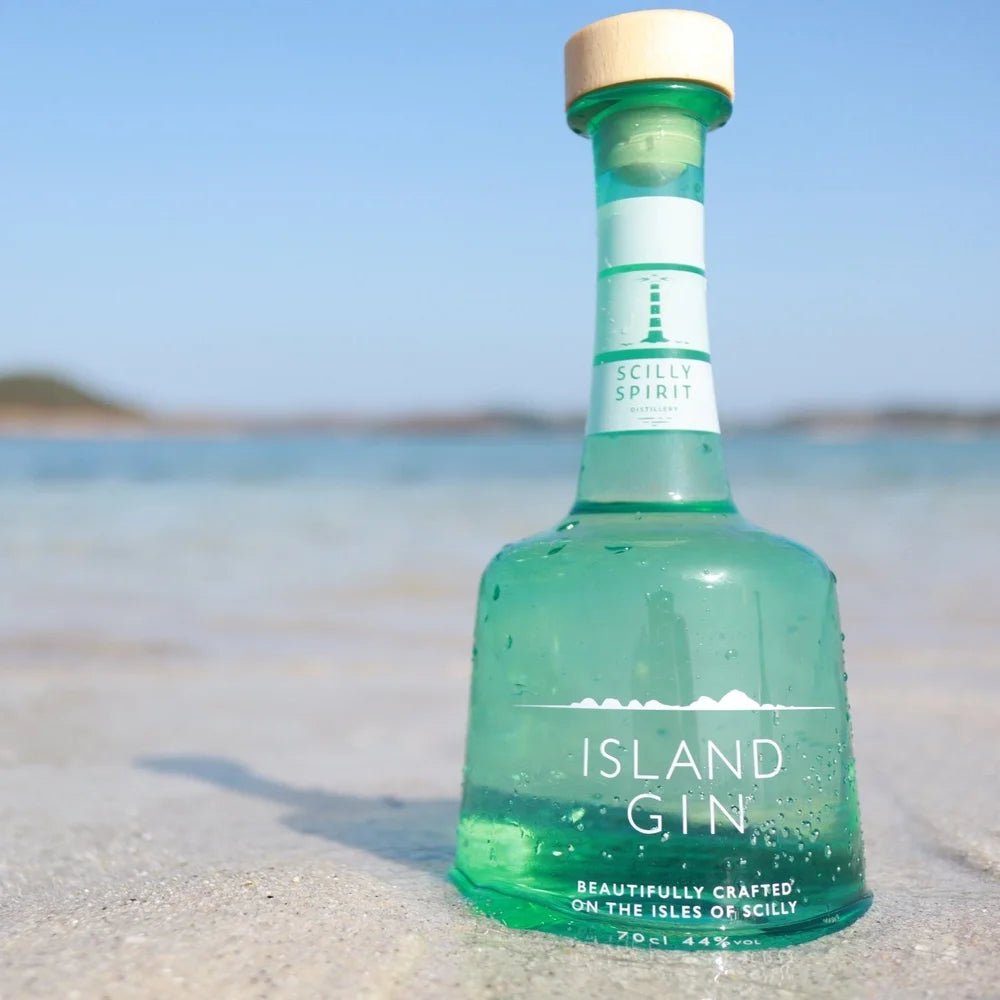 Bottle of Scilly Spirit Island Gin on a beach with clear blue sky