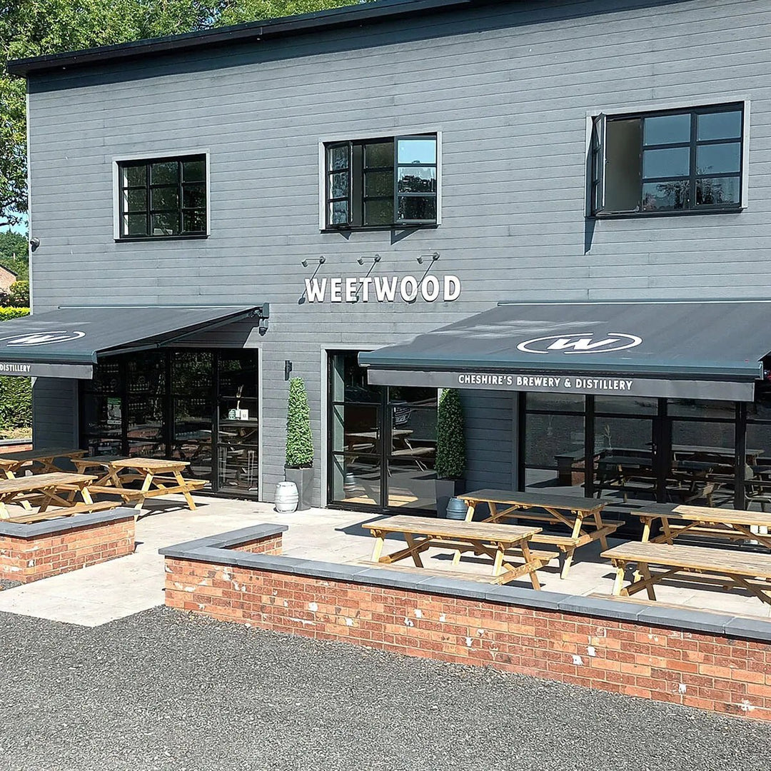 Exterior of a building with 'Wreetwood' branding, featuring outdoor seating and tables.