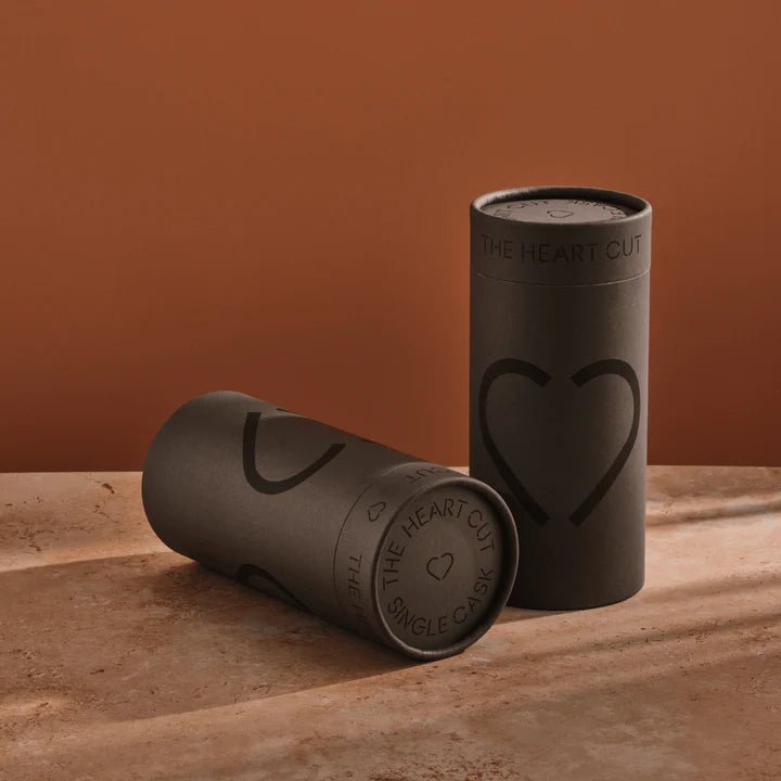 Two black cylindrical containers with heart designs on a brown surface and background.
