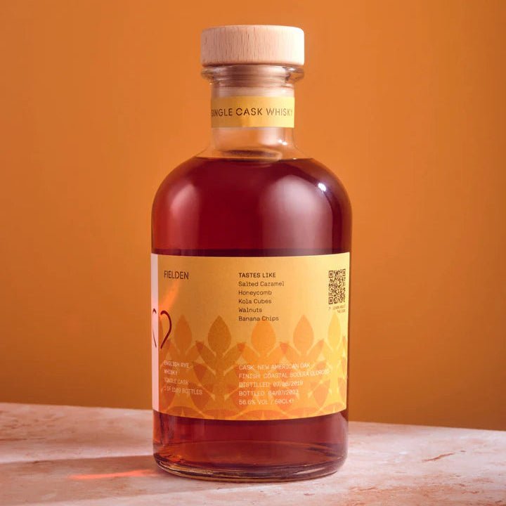 Bottle of The Heart Cut Fielden Whisky with a yellow label on an orange background