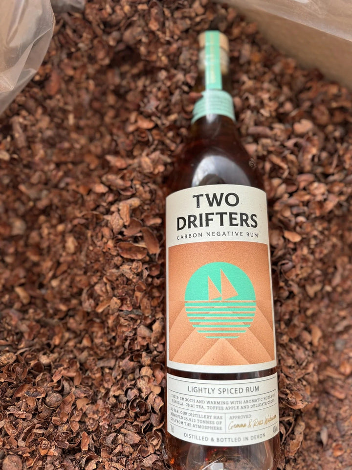 Bottle of Two Drifters rum on a background of dark wood chips