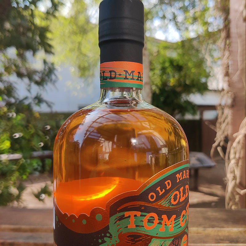 Bottle of Old Market Tom Cribbs Upper Cut Gin 59% Gin with a blurred outdoor background