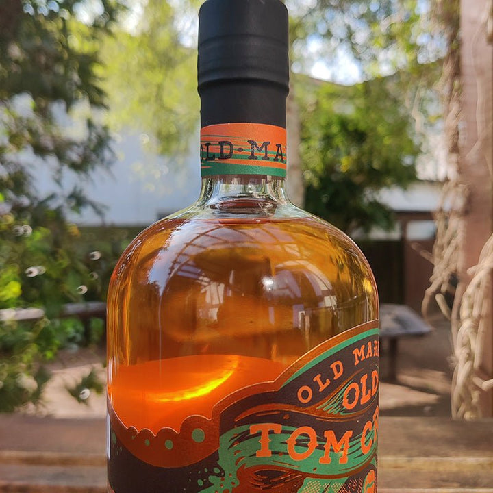 Bottle of Old Market Tom Cribbs Upper Cut Gin 59% Gin with a blurred outdoor background