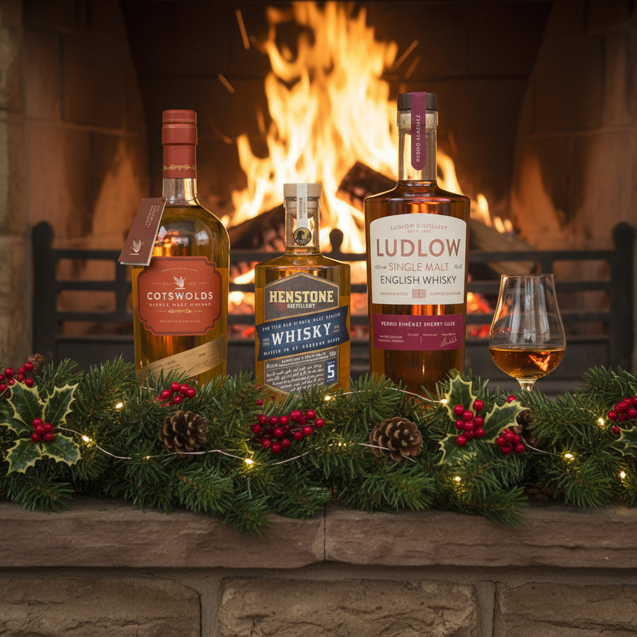 Three bottles of whisky from different distilleries on a hearth in front of an open fire