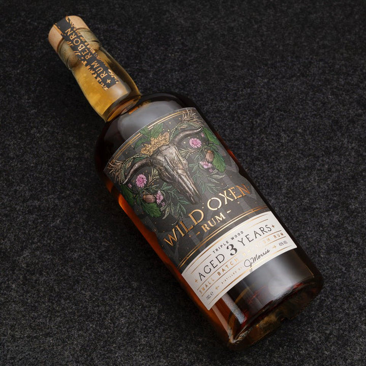 Bottle of Wild Oxen Rum aged 3 years on a dark textured background