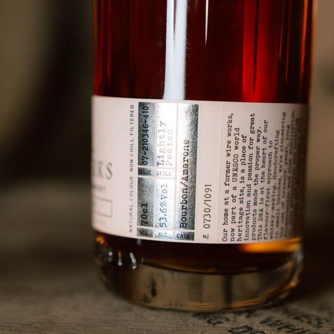 Close-up of a bottle of Wire Works Amarone cask whisky label on a wooden surface