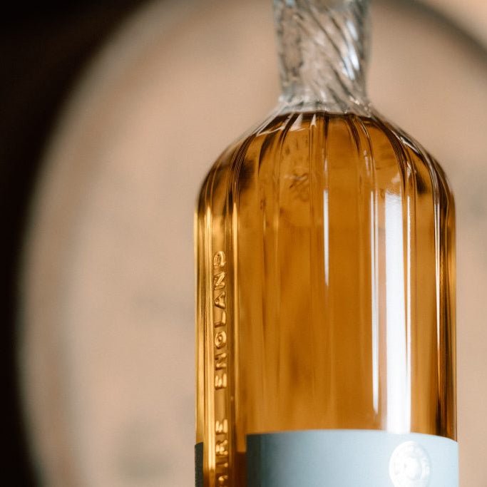Close-up of a Wire Works whisky bottle with a textured surface and a blurred background