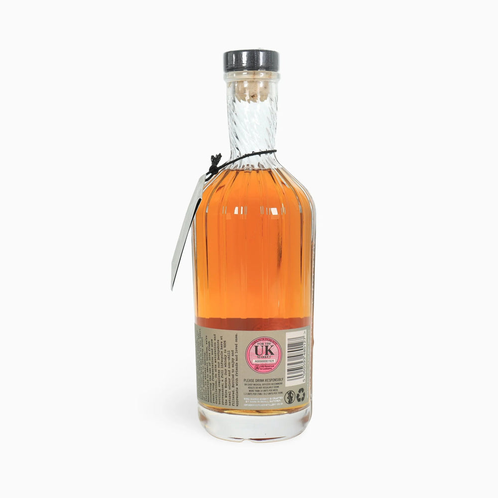 Bottle of White Peak Distillery First release English Whisky showing rear label on a white background