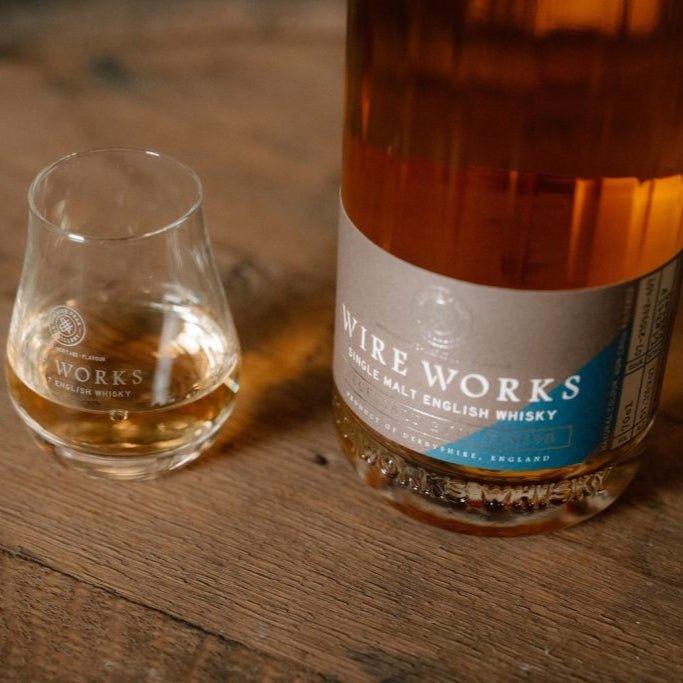 Wire Works whisky bottle and glass on a wooden surface