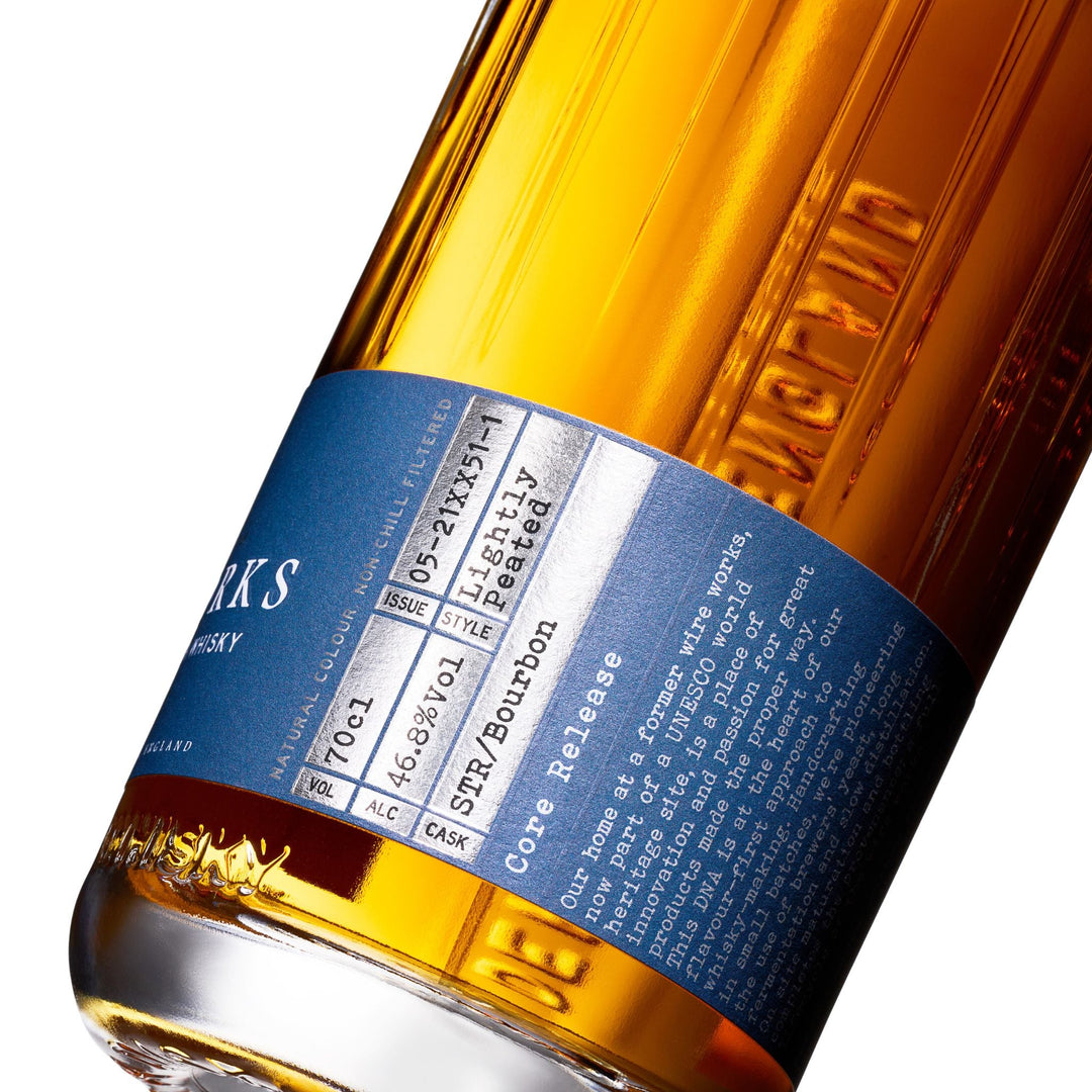 Close-up of a Wire Works Caduro whisky bottle label with text and branding.